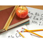 Schulbücher, Stifte und Apfel